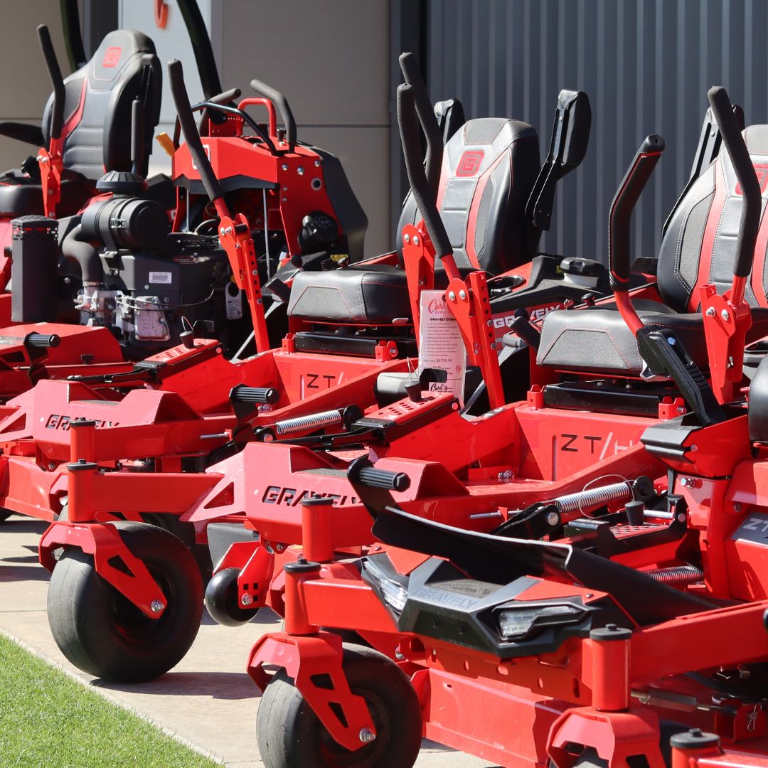 Gravely zero turn lawn mowers lined up on sidewalk