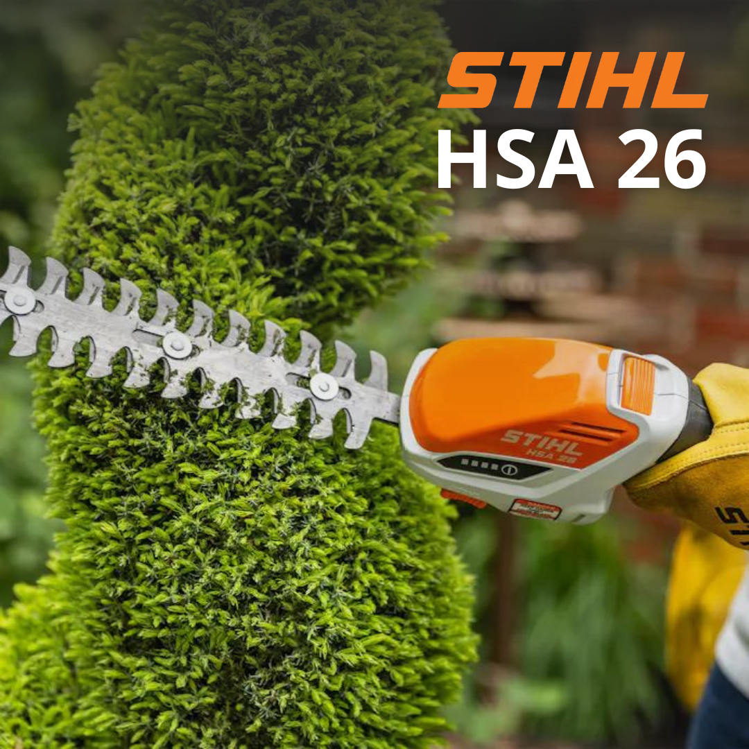 A gloved hand using a STIHL HSA 26 being to trim an ornamental shrub