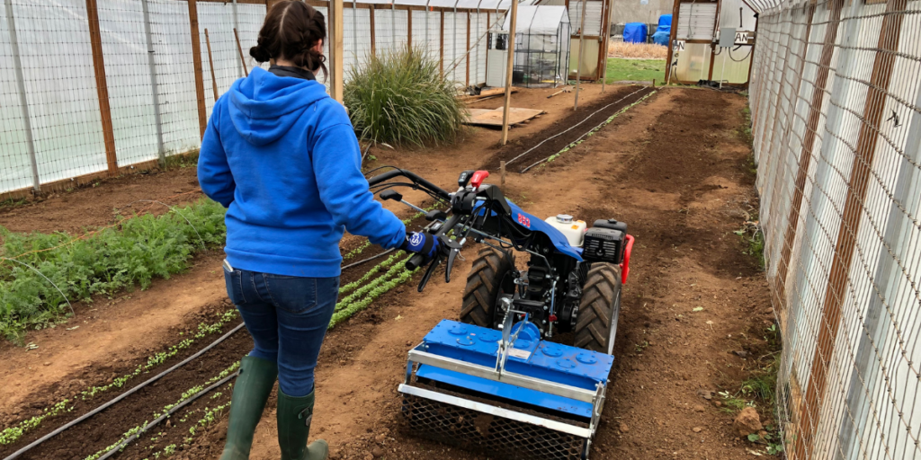 Woman operating BCS Walk-Behind Tractor in her greenhouse