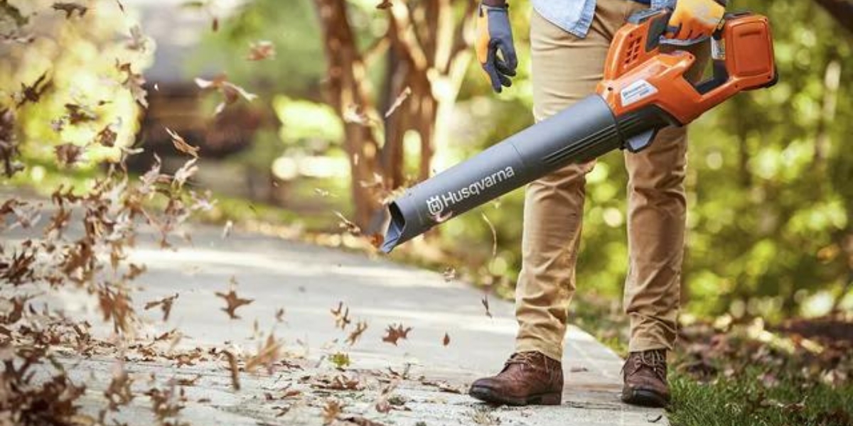 Person blowing leaves with Husqvarna 320iB blower