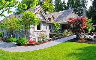 efficiency-boosting equipment for homeowners | image of a home with a nicely maintained yard of grass, trees, bushes and flowering plants